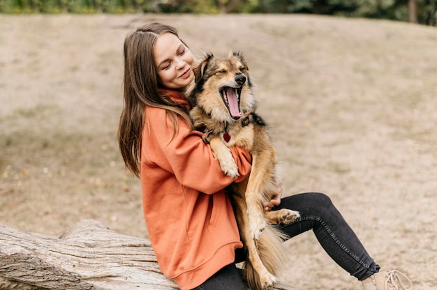 Bastante joven acariciando a su perro