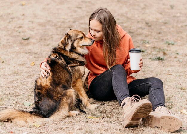 Bastante joven acariciando a su perro