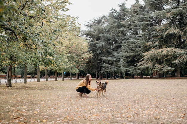 Bastante joven acariciando a su perro