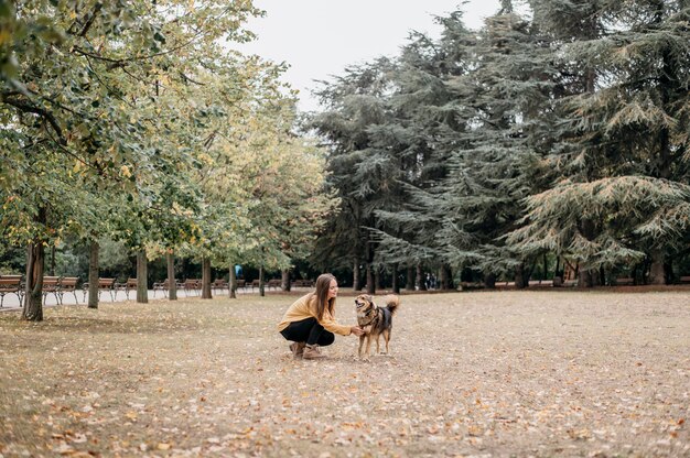 Bastante joven acariciando a su perro