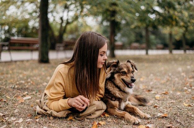 Bastante joven acariciando a su perro