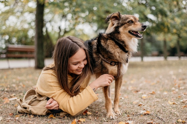 Bastante joven acariciando a su perro