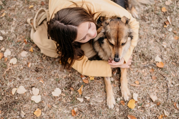 Bastante joven acariciando a su perro