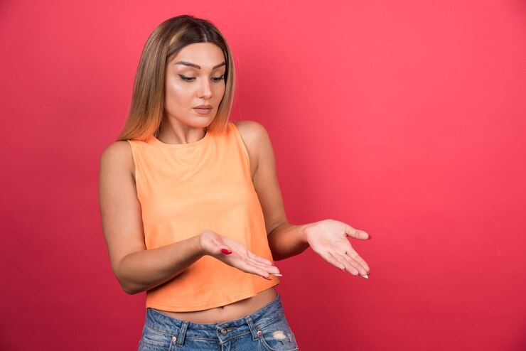 Foto gratuito bastante joven confundida mirándola hacia abajo.