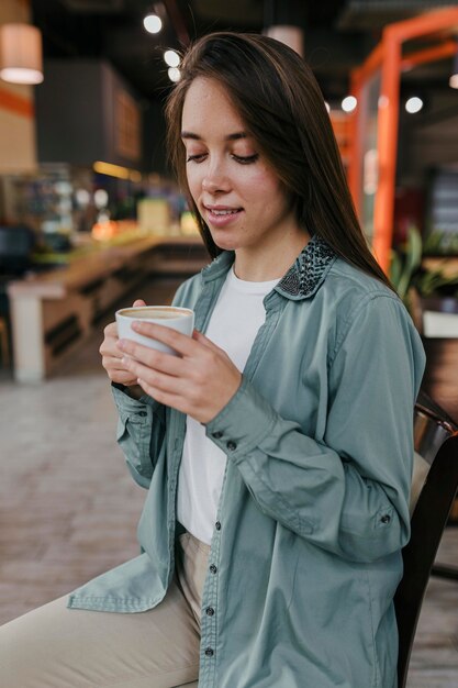 Bastante joven disfrutando de una taza de café