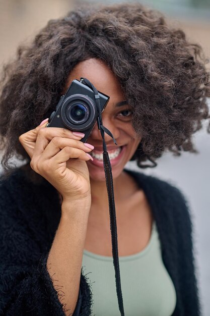 Bastante joven fotógrafa sonriendo positivamente