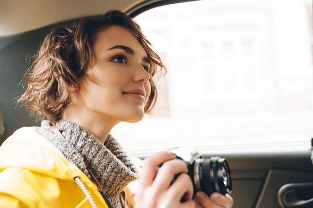 Bastante joven fotógrafo vestido con gabardina