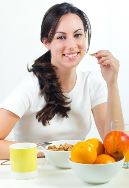 Bastante joven mujer desayunando en casa