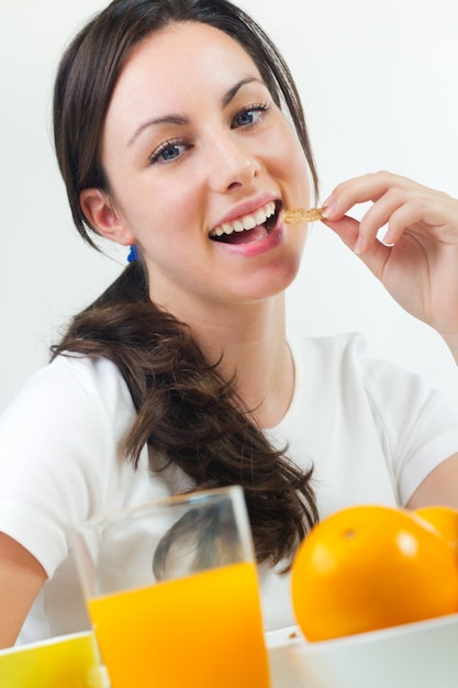 Bastante joven mujer desayunando en casa