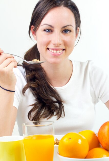 Bastante joven mujer desayunando en casa