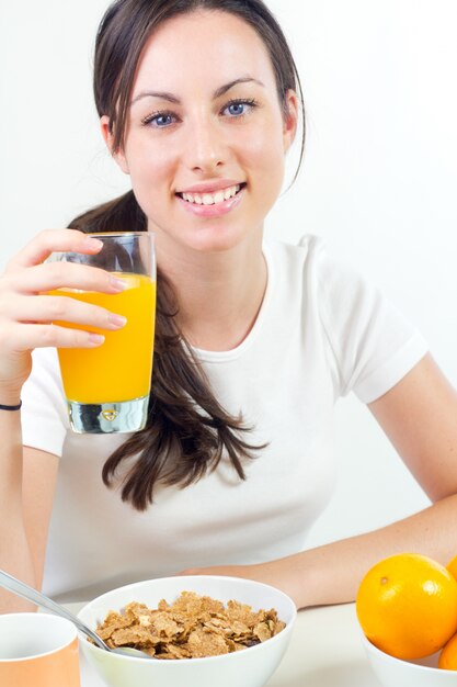 Bastante joven mujer desayunando en casa