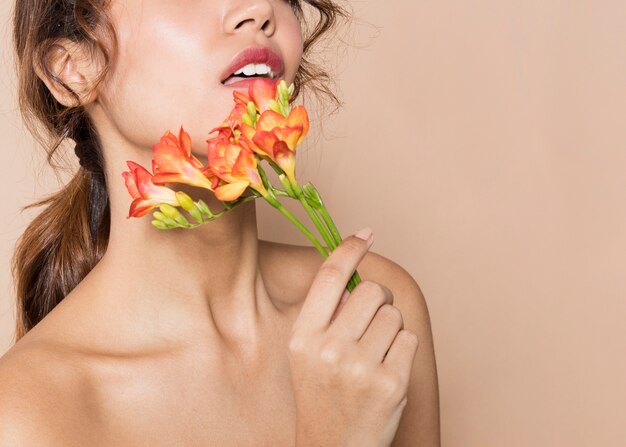 Bastante joven mujer sosteniendo flores vibrantes