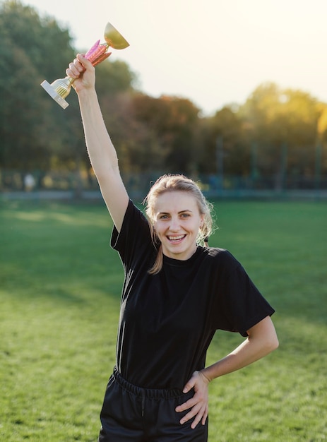 Bastante joven mujer sosteniendo un trofeo