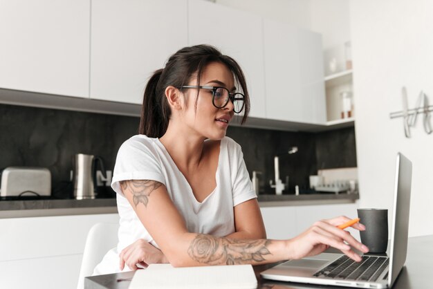 Bastante joven mujer usando laptop.