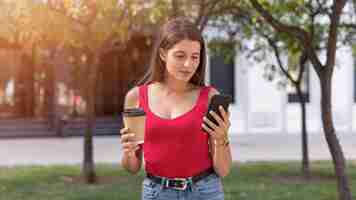 Foto gratuita bastante joven navegando por teléfono móvil