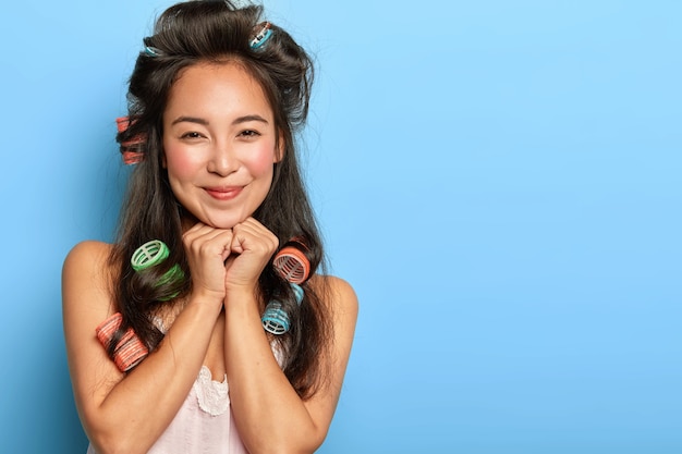 Foto gratuita bastante joven posando con rizadores de pelo