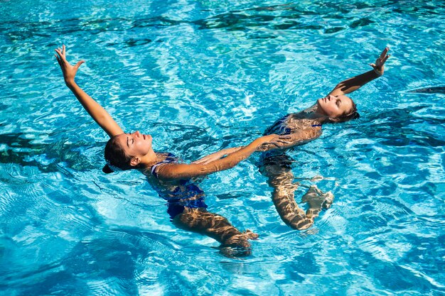 Bastante jovencitas disfrutando del tiempo en la piscina