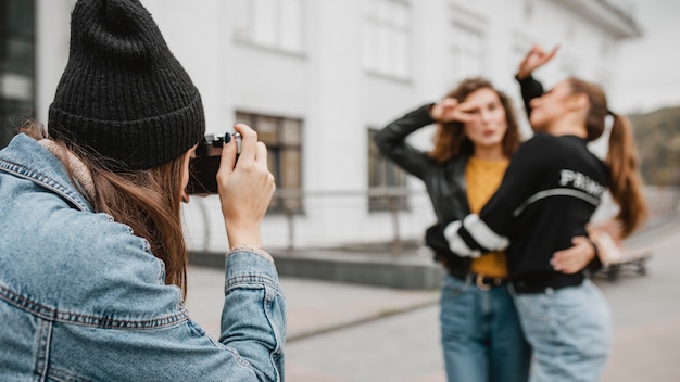 Foto gratuita bastante jovencitas tomando fotografías al aire libre