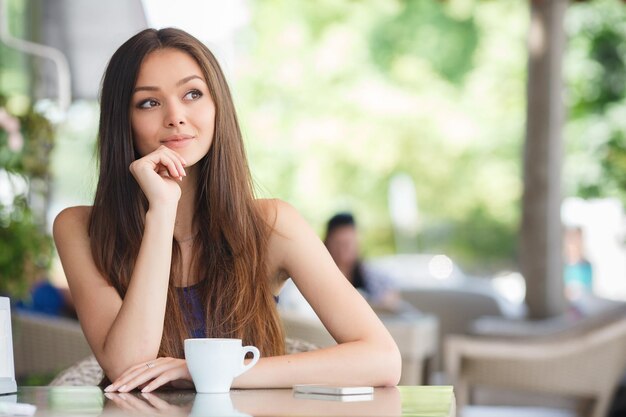 bastante, mujer joven, con, té, en, café, terraza, al aire libre