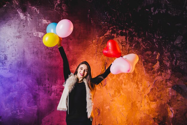 Bastante mujer de pie con globos