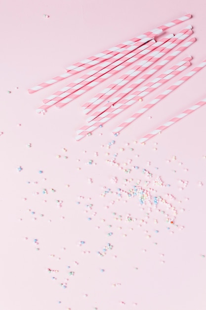Foto gratuita bastón de caramelo y maja asperja sobre fondo rosa