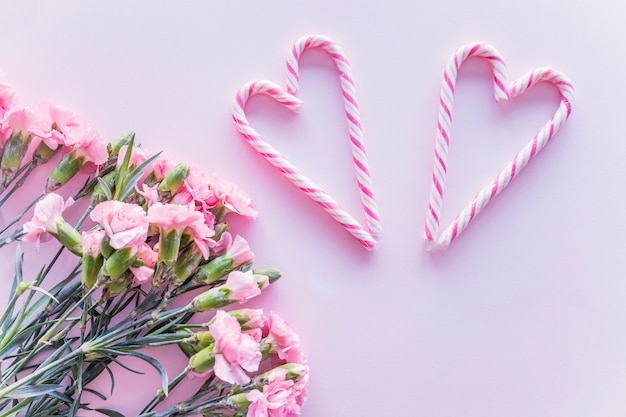 Bastones de caramelo en forma de corazón con flores