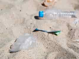 Foto gratuita basura de residuos plásticos en la arena de la playa