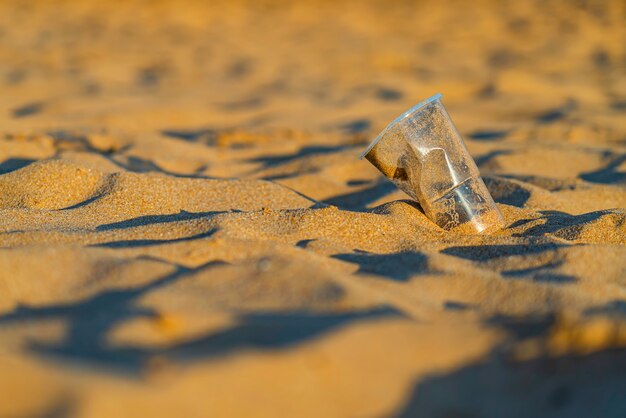 Basura Vaso de plástico en la playa de arena dorada del océano, playa de las Teresitas, Tenerife. Concepto de conservación del medio ambiente. Mares y contaminación de los océanos con residuos plásticos. Reciclar.