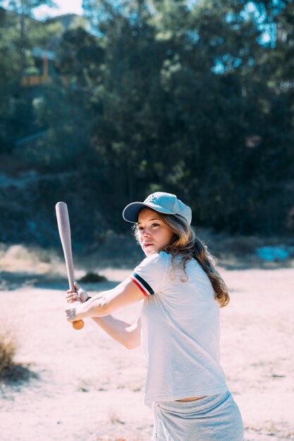 Bate de béisbol de balanceo del estudiante adolescente concentrado