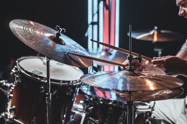 Foto gratuita el baterista juega con una hermosa iluminación sobre un fondo borroso.