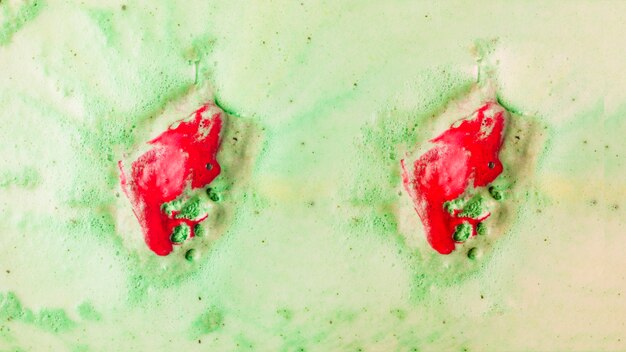 Bathbomb rojo se disuelve en agua de baño de burbuja verde