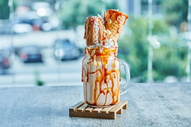 Batido de anillo de caramelo en la placa de madera sobre la mesa de mármol.