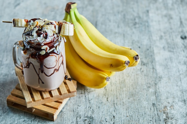 Foto gratuita batido de chocolate con sirope de choco y rama de plátano