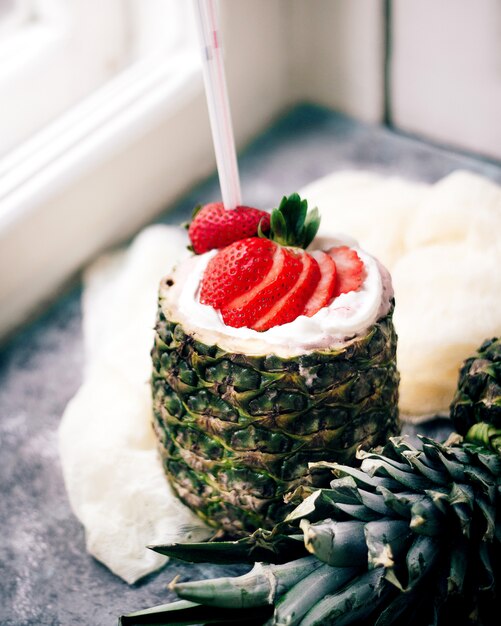 Batido de leche con fresas servidas dentro de la piña