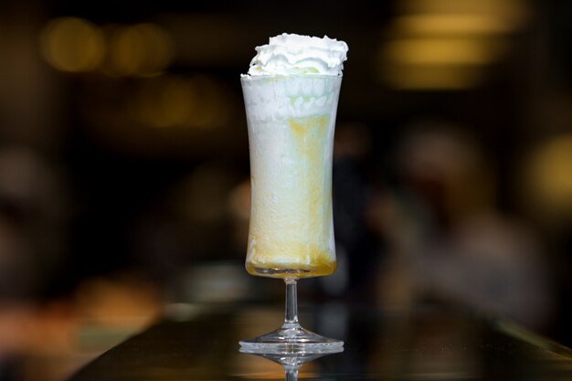 Batido de naranja con crema batida en un vaso largo