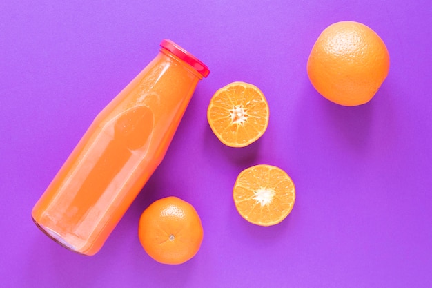 Foto gratuita batido de naranja fresco en botella