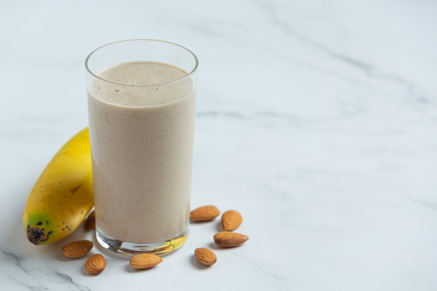 Batido de plátano y almendra sobre fondo de mármol