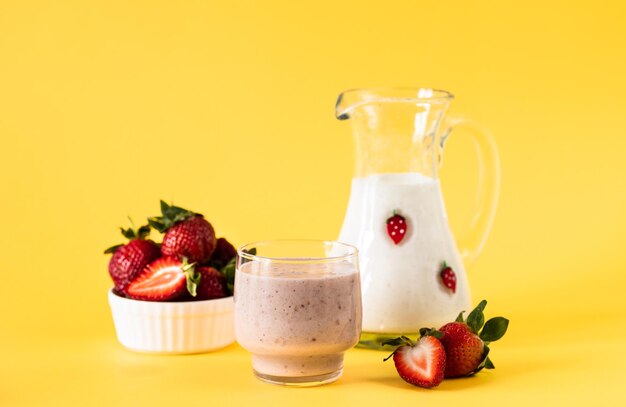 Batido rosa con plátano y fresa sobre un fondo amarillo dieta saludable y estilo de vida nutricional