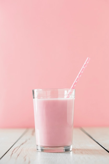 Batido rosa en vaso con paja