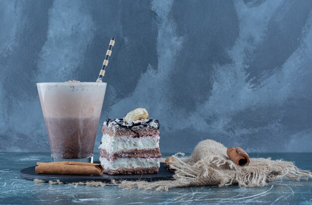 Batido, tarta y canela en el tablero, sobre fondo azul. Foto de alta calidad