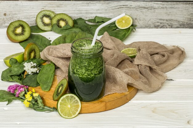 batido verde en una jarra con lima y bayas