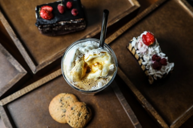 Batido de vista superior con capuchino en un vaso con galletas en una bandeja