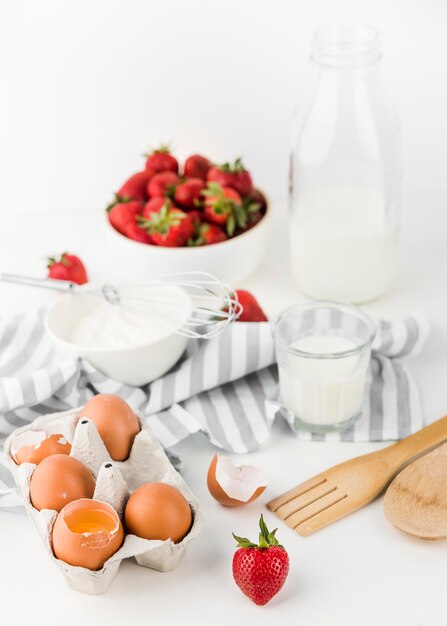 Batidor de primer plano con fresas y huevos