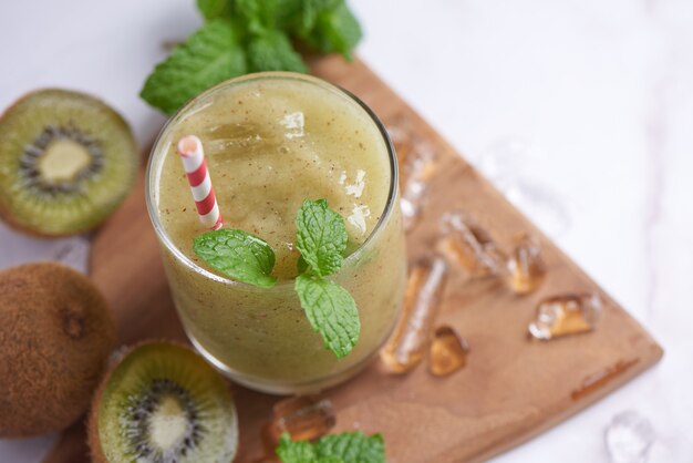 Batidos de kiwi caseros frescos con leche, menta y miel. Bebida orgánica saludable. Primer plano y enfoque selectivo. Fruta verde recién mezclada, concepto de bienestar y pérdida de peso.