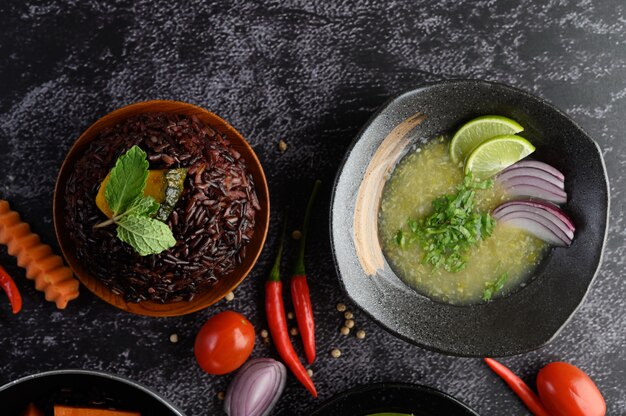 Bayas de arroz morado con calabaza y hojas de menta en un tazón y sopa