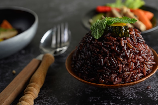 Bayas de arroz morado cocidas con pechuga de pollo a la parrilla Calabaza Hojas de zanahoria Las hojas de menta en el plato y la cuchara, tenedor, comida limpia.