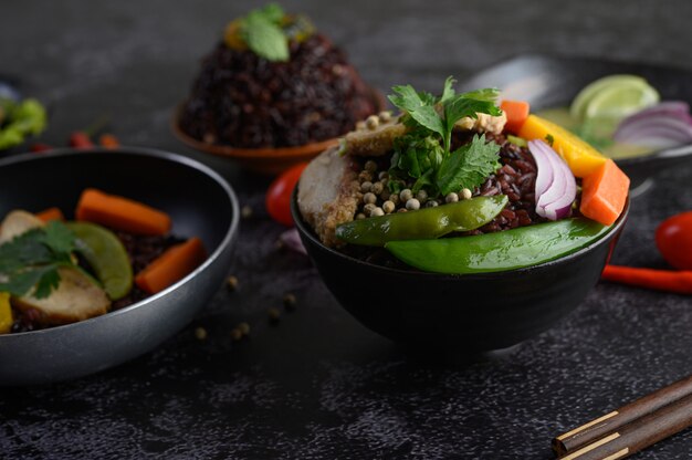 Bayas de arroz morado con frijoles, zanahoria y hojas de menta en un tazón