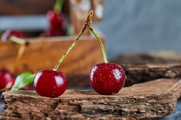 Bayas de cereza roja jugosa en una pieza de madera