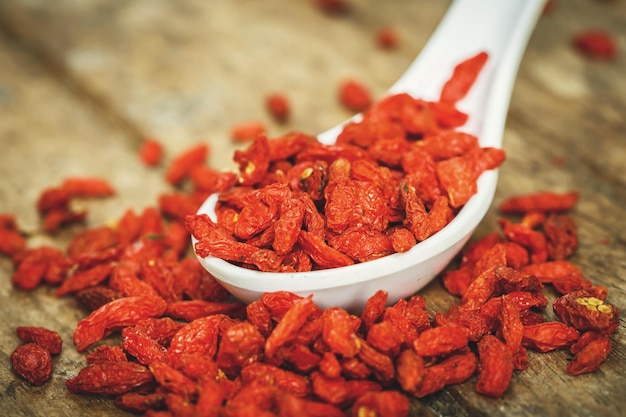 Bayas de Goji en una cuchara sobre una tabla de madera