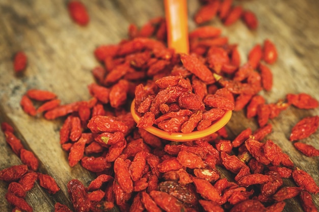 Bayas de Goji en una cuchara sobre una tabla de madera